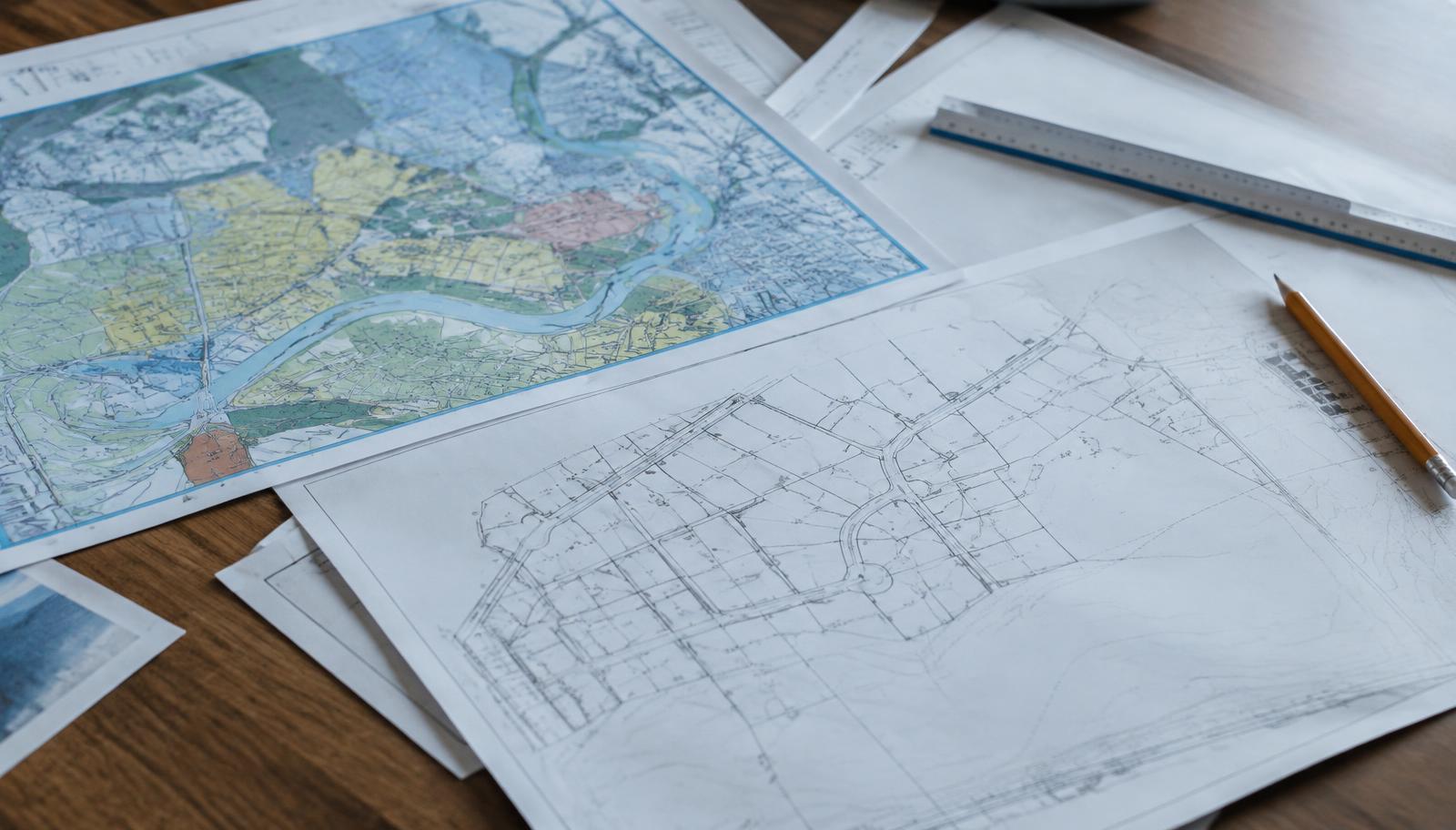 Zoning map and plat drawings spread on a desk